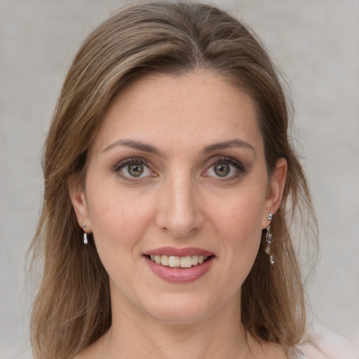 Joyful white young-adult female with medium  brown hair and grey eyes