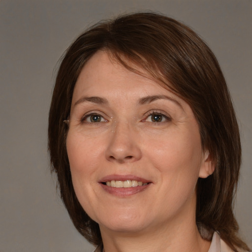 Joyful white adult female with medium  brown hair and brown eyes