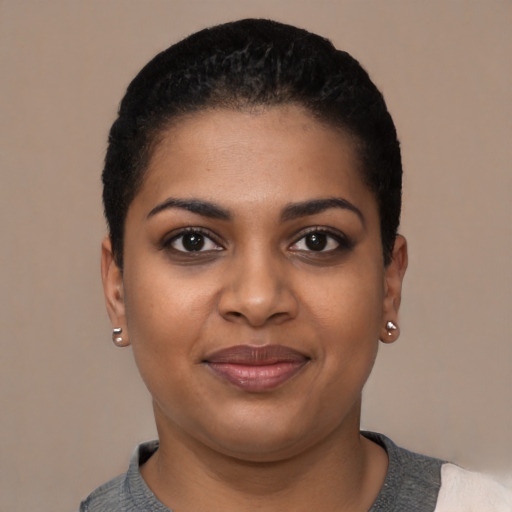 Joyful black young-adult female with short  black hair and brown eyes