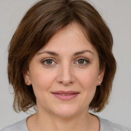 Joyful white young-adult female with medium  brown hair and green eyes