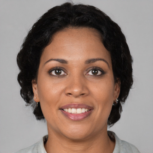 Joyful black young-adult female with medium  black hair and brown eyes