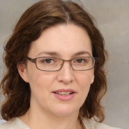 Joyful white adult female with medium  brown hair and green eyes