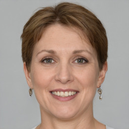 Joyful white adult female with medium  brown hair and grey eyes