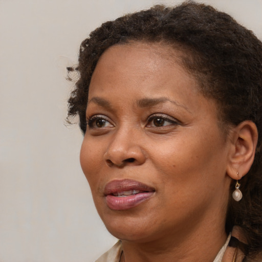 Joyful black adult female with medium  brown hair and brown eyes