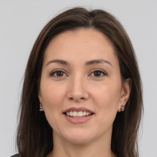 Joyful white young-adult female with long  brown hair and brown eyes