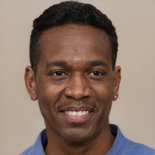 Joyful black young-adult male with short  black hair and brown eyes