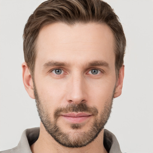 Joyful white young-adult male with short  brown hair and grey eyes