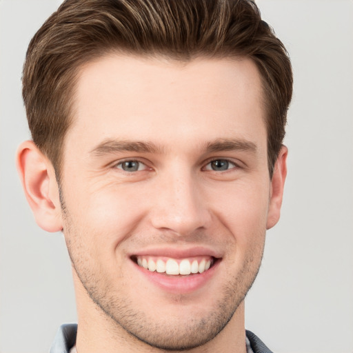 Joyful white young-adult male with short  brown hair and grey eyes