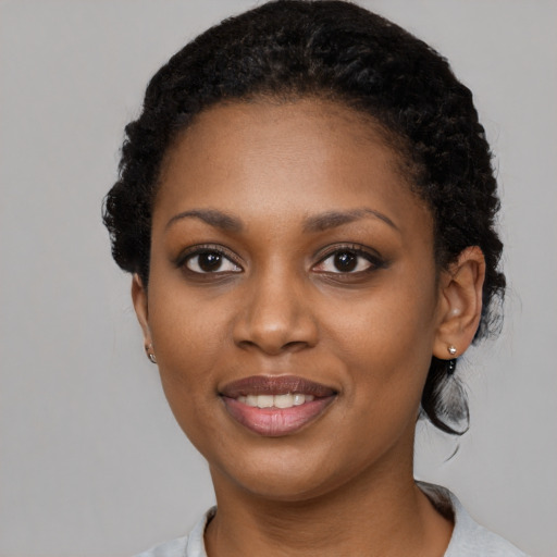 Joyful black young-adult female with short  black hair and brown eyes