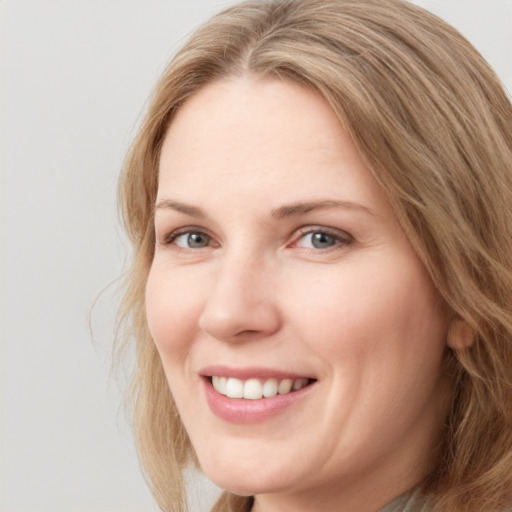 Joyful white young-adult female with long  brown hair and blue eyes