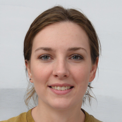 Joyful white young-adult female with medium  brown hair and grey eyes