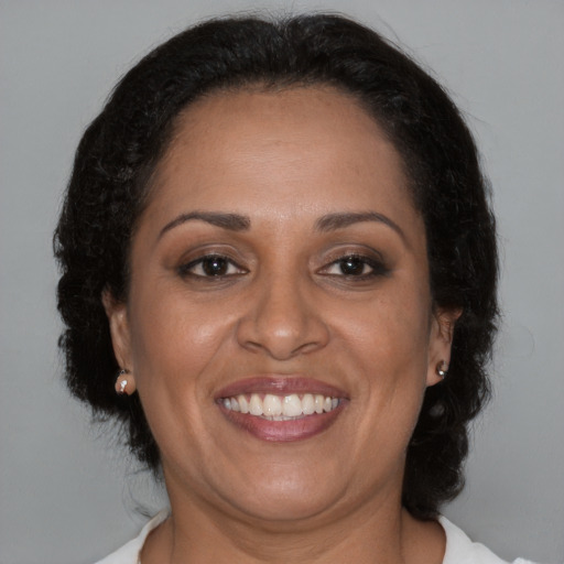 Joyful black adult female with medium  brown hair and brown eyes