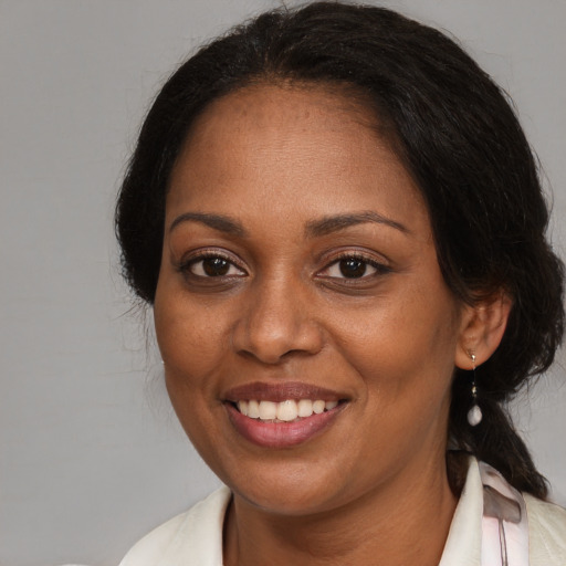 Joyful black adult female with medium  brown hair and brown eyes