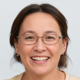 Joyful white adult female with medium  brown hair and grey eyes