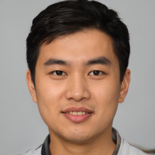 Joyful asian young-adult male with short  black hair and brown eyes