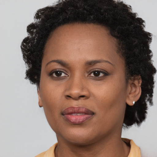 Joyful black adult female with short  brown hair and brown eyes