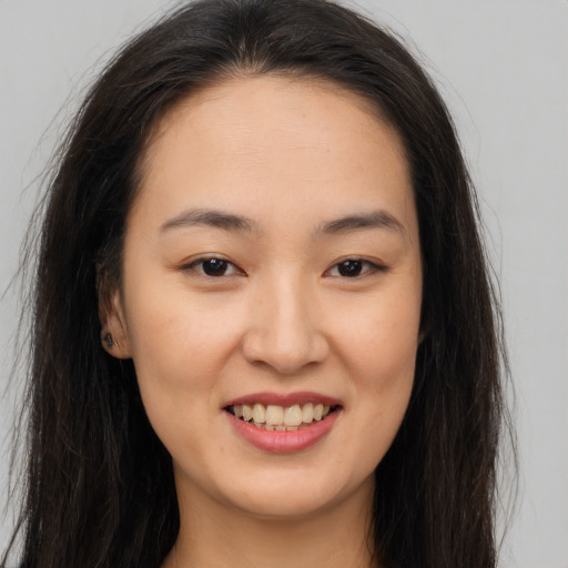 Joyful asian young-adult female with long  brown hair and brown eyes