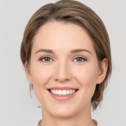 Joyful white young-adult female with medium  brown hair and green eyes