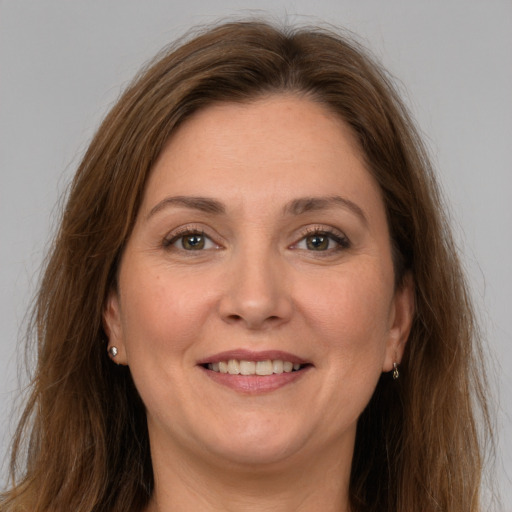 Joyful white adult female with long  brown hair and grey eyes