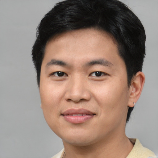 Joyful asian young-adult male with short  black hair and brown eyes