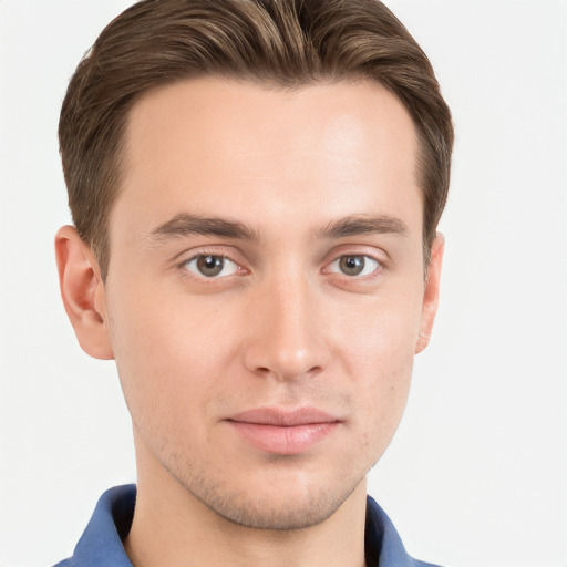 Joyful white young-adult male with short  brown hair and grey eyes