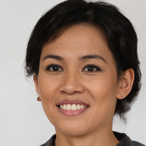 Joyful asian young-adult female with medium  black hair and brown eyes