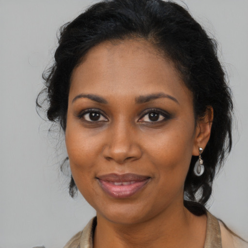 Joyful black young-adult female with long  brown hair and brown eyes