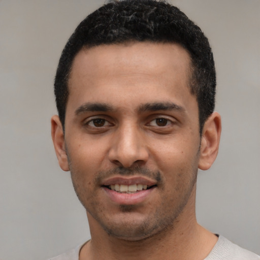 Joyful white young-adult male with short  black hair and brown eyes