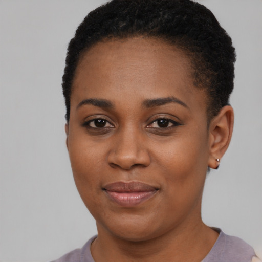 Joyful black young-adult female with short  black hair and brown eyes