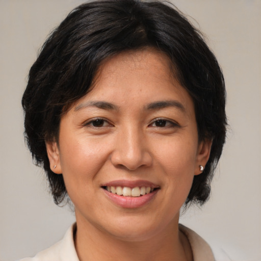Joyful asian adult female with medium  brown hair and brown eyes