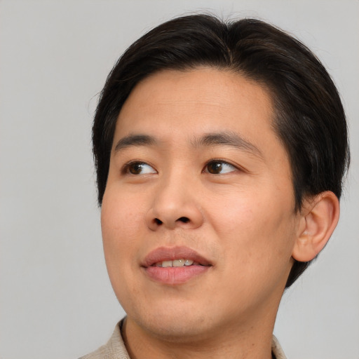 Joyful asian young-adult male with short  brown hair and brown eyes