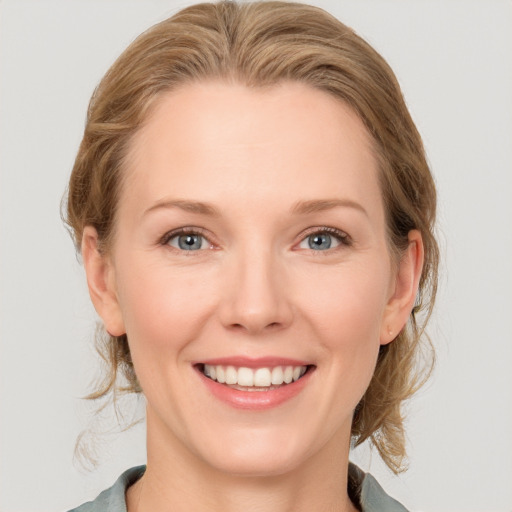 Joyful white young-adult female with medium  brown hair and blue eyes