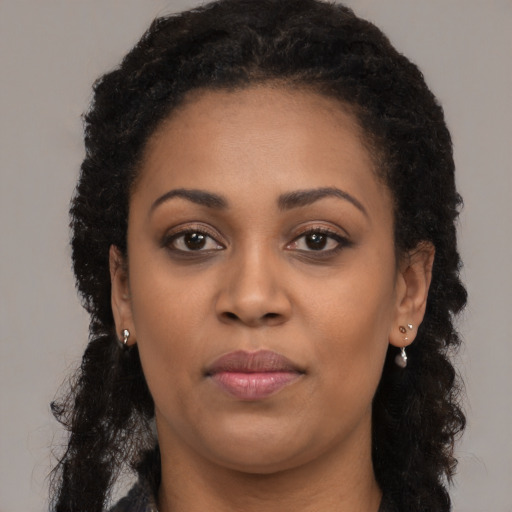 Joyful black young-adult female with long  brown hair and brown eyes
