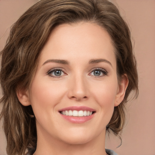 Joyful white young-adult female with medium  brown hair and green eyes