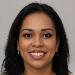 Joyful latino young-adult female with long  brown hair and brown eyes