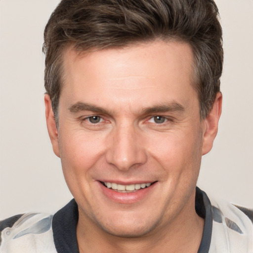 Joyful white adult male with short  brown hair and brown eyes