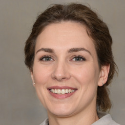 Joyful white adult female with medium  brown hair and grey eyes