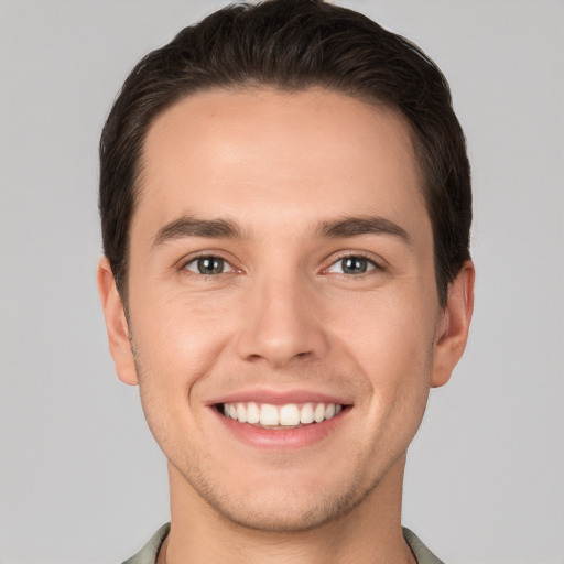 Joyful white young-adult male with short  brown hair and grey eyes