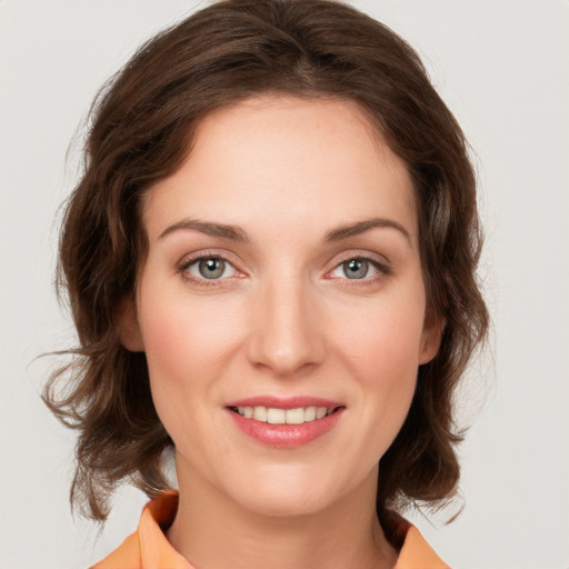 Joyful white young-adult female with medium  brown hair and green eyes