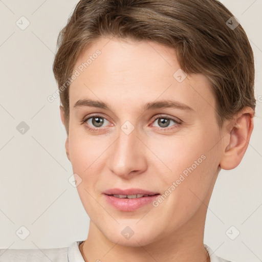 Joyful white young-adult female with short  brown hair and grey eyes