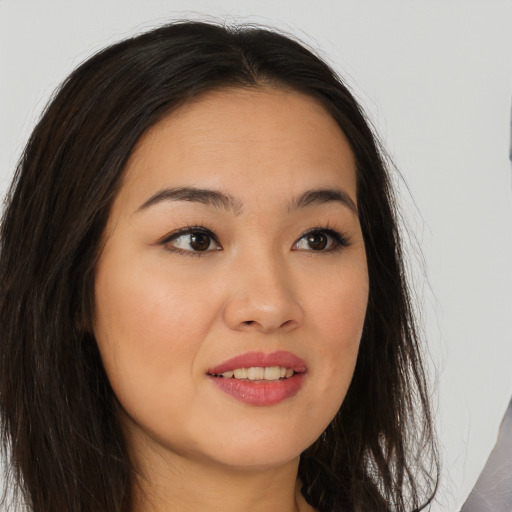 Joyful asian young-adult female with long  brown hair and brown eyes