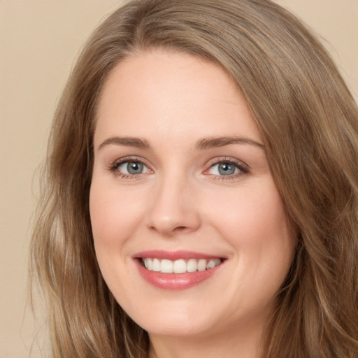 Joyful white young-adult female with long  brown hair and green eyes