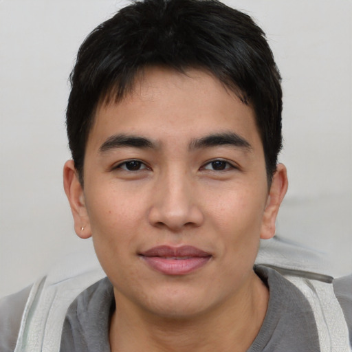 Joyful asian young-adult male with short  black hair and brown eyes