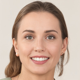 Joyful white young-adult female with medium  brown hair and grey eyes