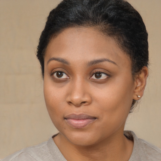 Joyful black young-adult female with short  brown hair and brown eyes