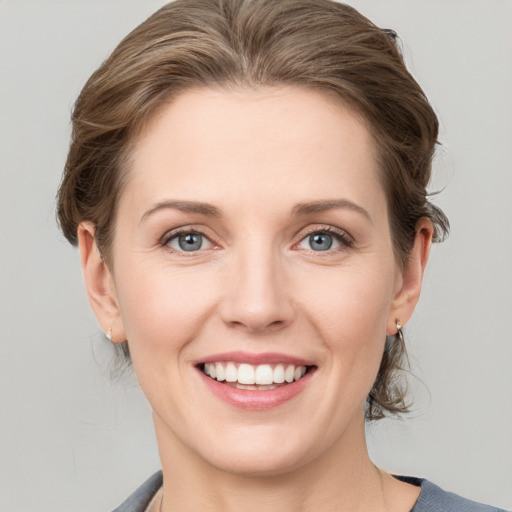 Joyful white young-adult female with medium  brown hair and grey eyes