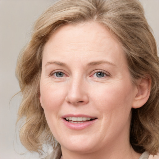 Joyful white adult female with medium  brown hair and blue eyes