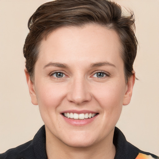 Joyful white young-adult female with short  brown hair and grey eyes