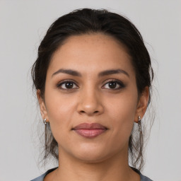 Joyful latino young-adult female with medium  brown hair and brown eyes