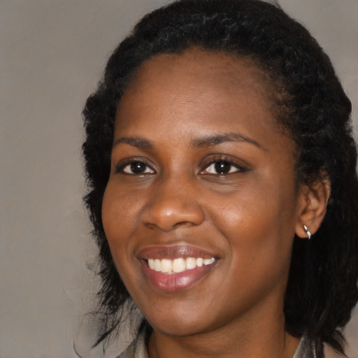 Joyful black young-adult female with long  black hair and brown eyes